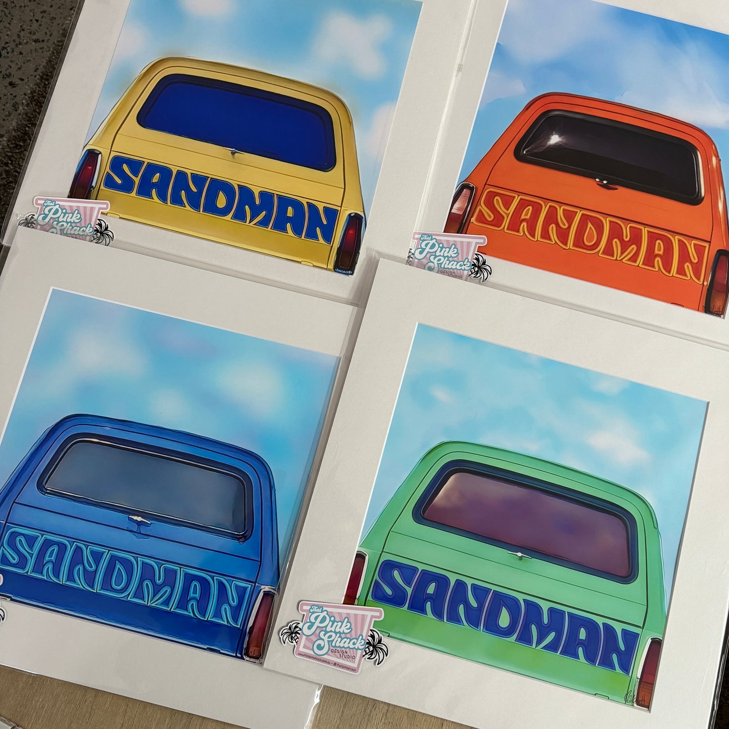 4 prints in mats of different coloured holden sandman panelvans