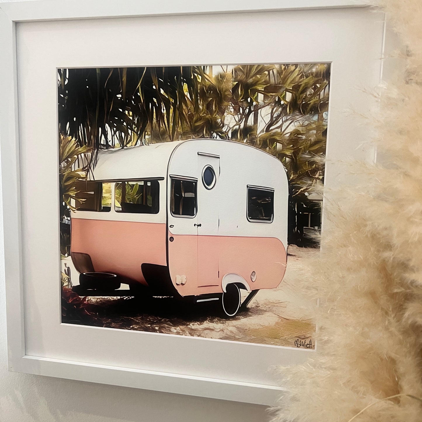 A pink and white vintage bondwood caravan with some trees surrounding it print With a white mat and a white frame