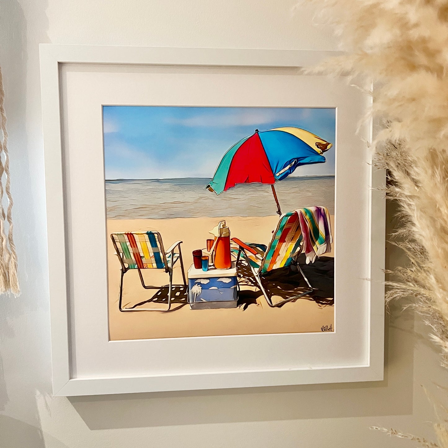 Bright colourful camp chairs, esky and beach umbrella sitting on the beach print In white frame