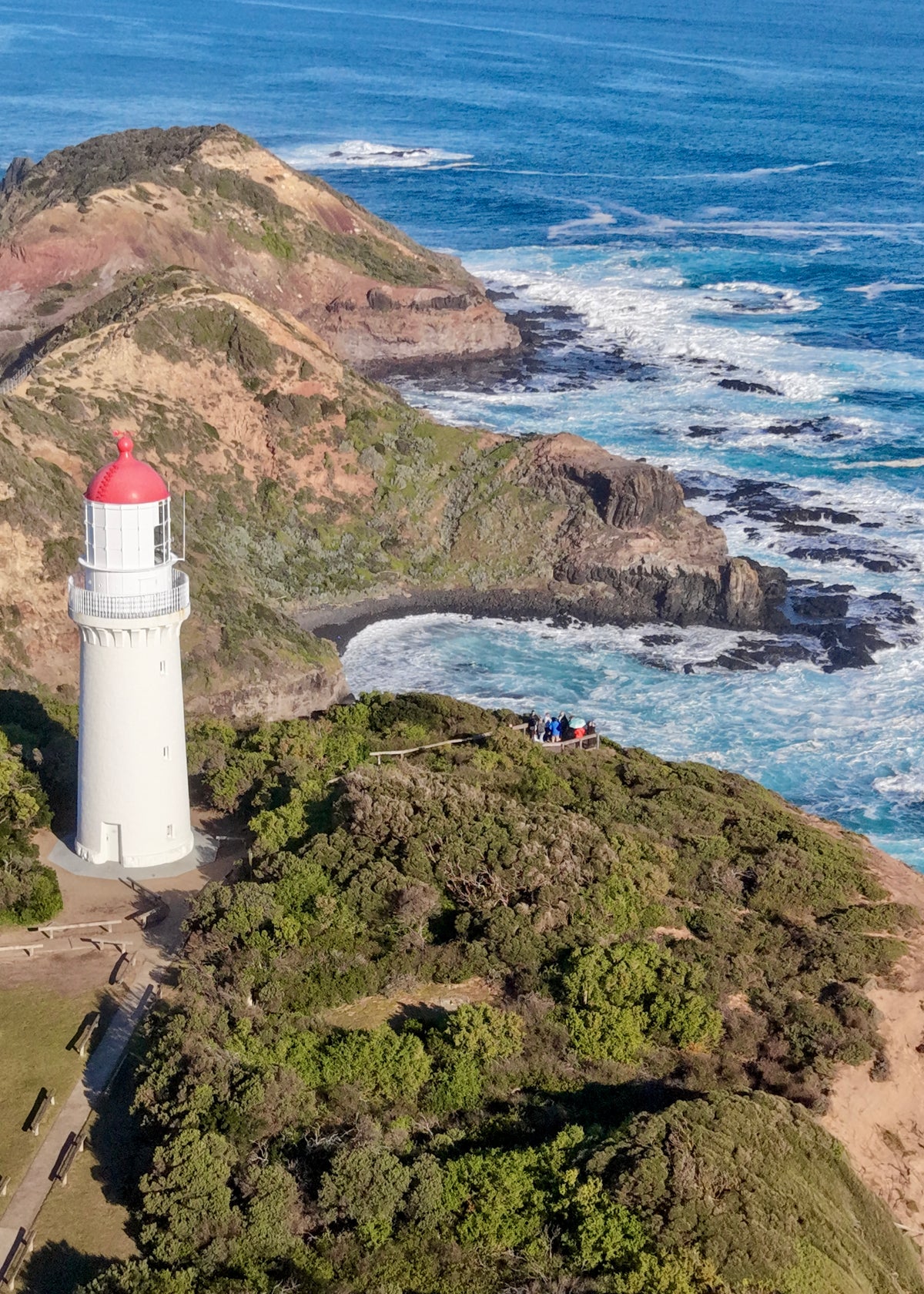 Aerial photograph of Cape Schanck Lighthouse overlooking the rugged coastline and blue ocean on the Mornington Peninsula, Victoria.