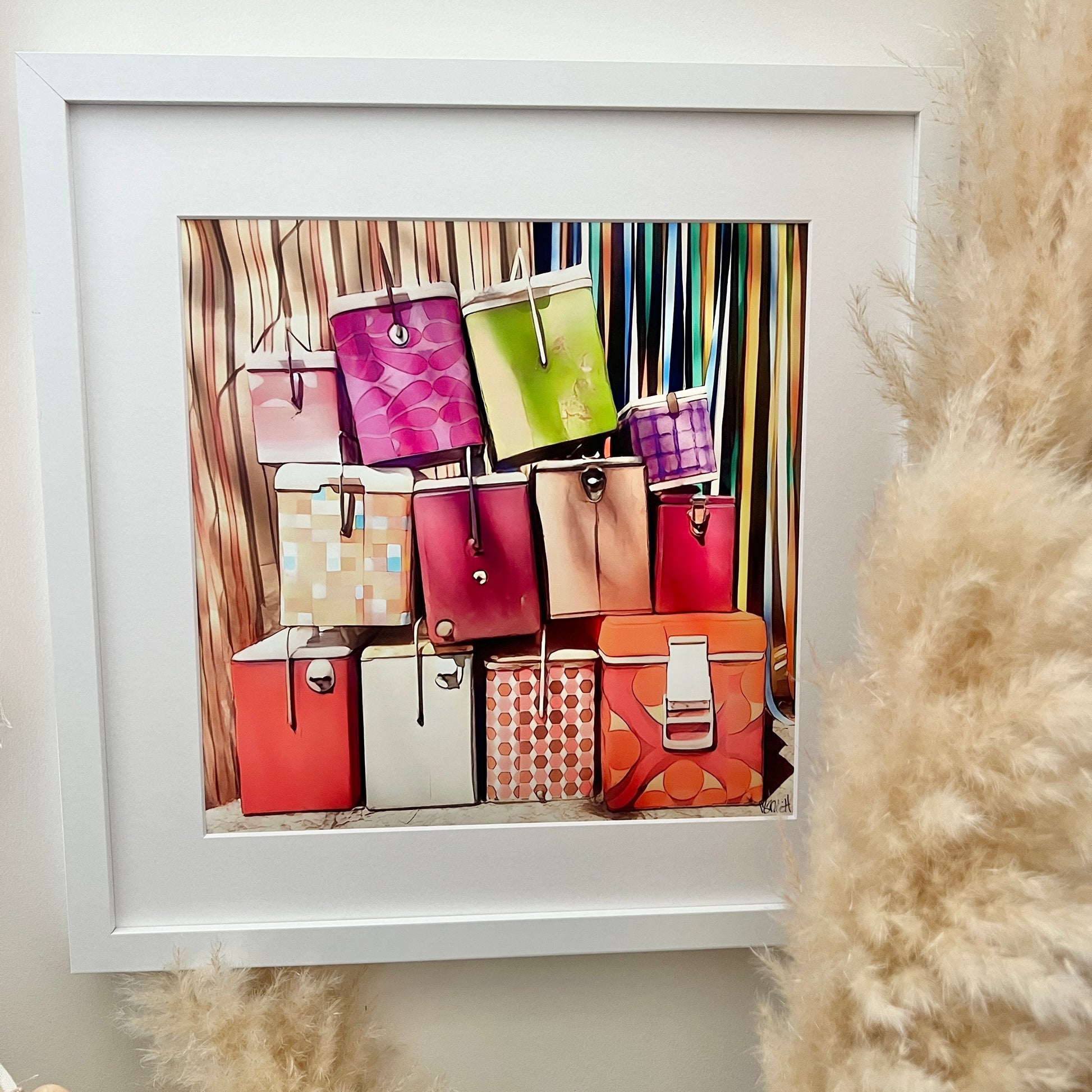A bunch of 12 colourful eskies stacked on top of each other sitting outside a retro caravan annexe print in a white mat with a white frame