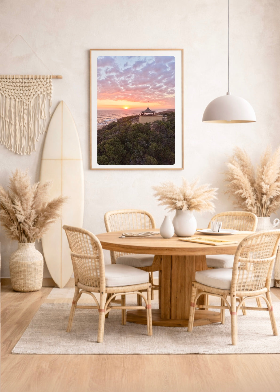 Dining room with round wooden table, wicker chairs, and a large framed picture of Coppins lookout , Sorrento at sunset 