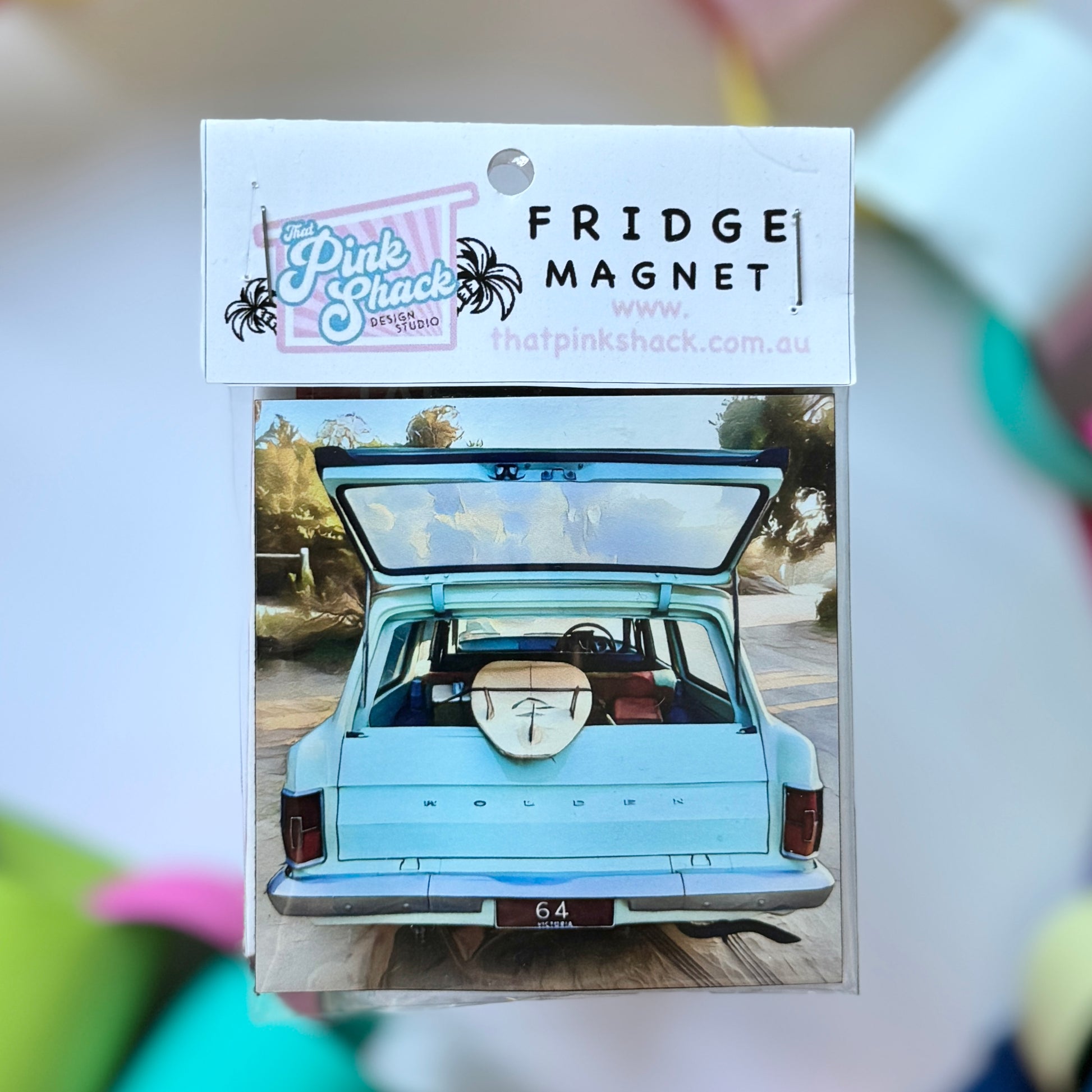 A classic eh Holden with a surfboard fridge magnet in packaging