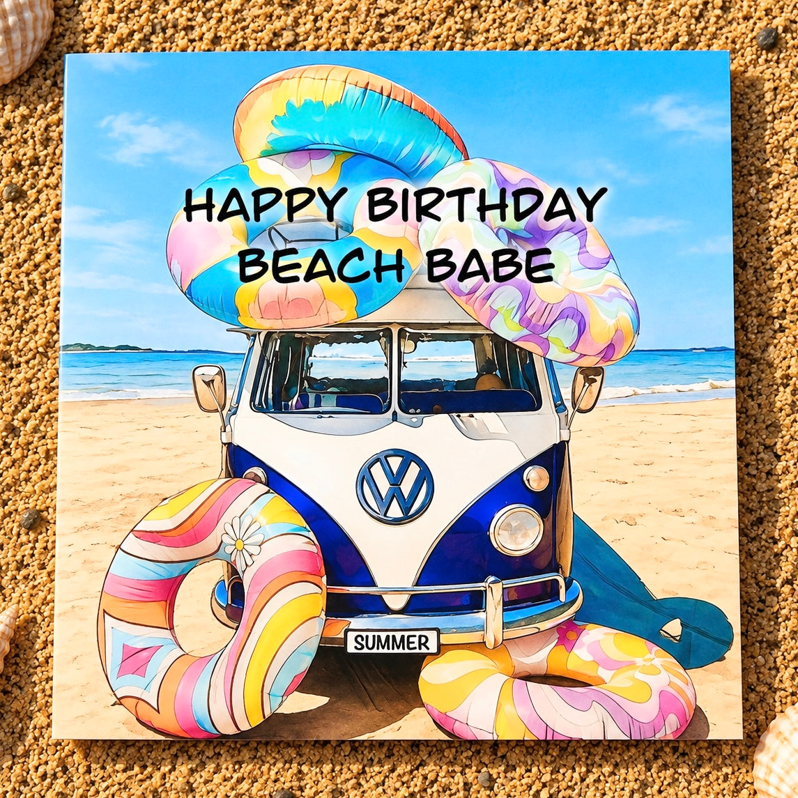 A square greeting card featuring a retro VW bus on a sandy beach with colourful inflatable rings , with the text 'HAPPY BIRTHDAY BEACH BABE' overlaid, displayed on a sandy surface.