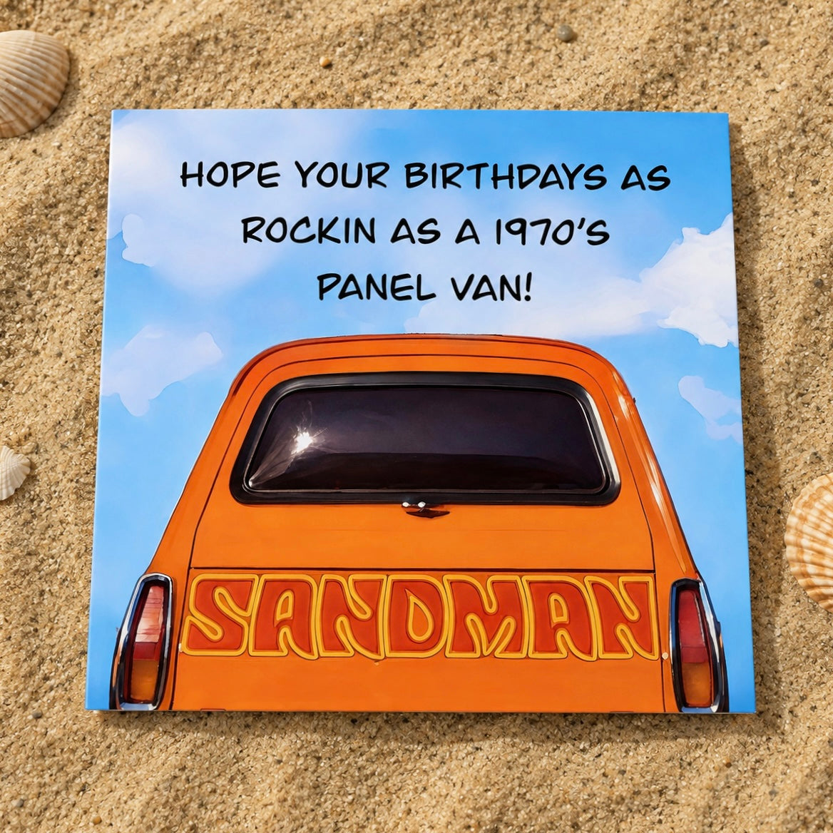 A square printed card  placed on sand, featuring an orange vintage panel van with the word 'SANDMAN' on the back and the text 'HOPE YOUR BIRTHDAYS AS ROCKIN AS A 1970'S PANEL VAN!' against a blue sky background.
