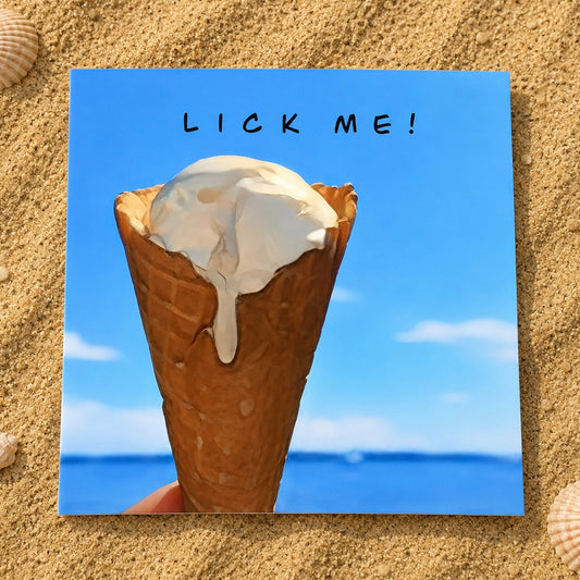 A square greeting card featuring a painted ice cream cone in a waffle cone with the text 'LICK ME!' on a blue sky and ocean background, placed on a sandy surface with seashells around it.
