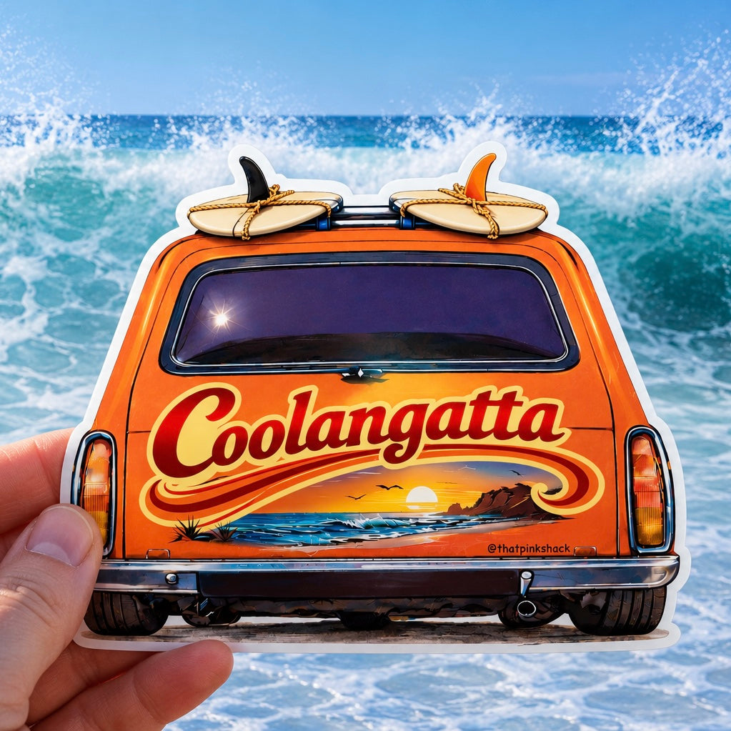 A die-cut sticker of a retro orange van with surfboards on its roof, held by a hand against a background of ocean waves. The back of the van features the text 'Coolangatta' in red with a yellow outline, above a sunset beach scene.
