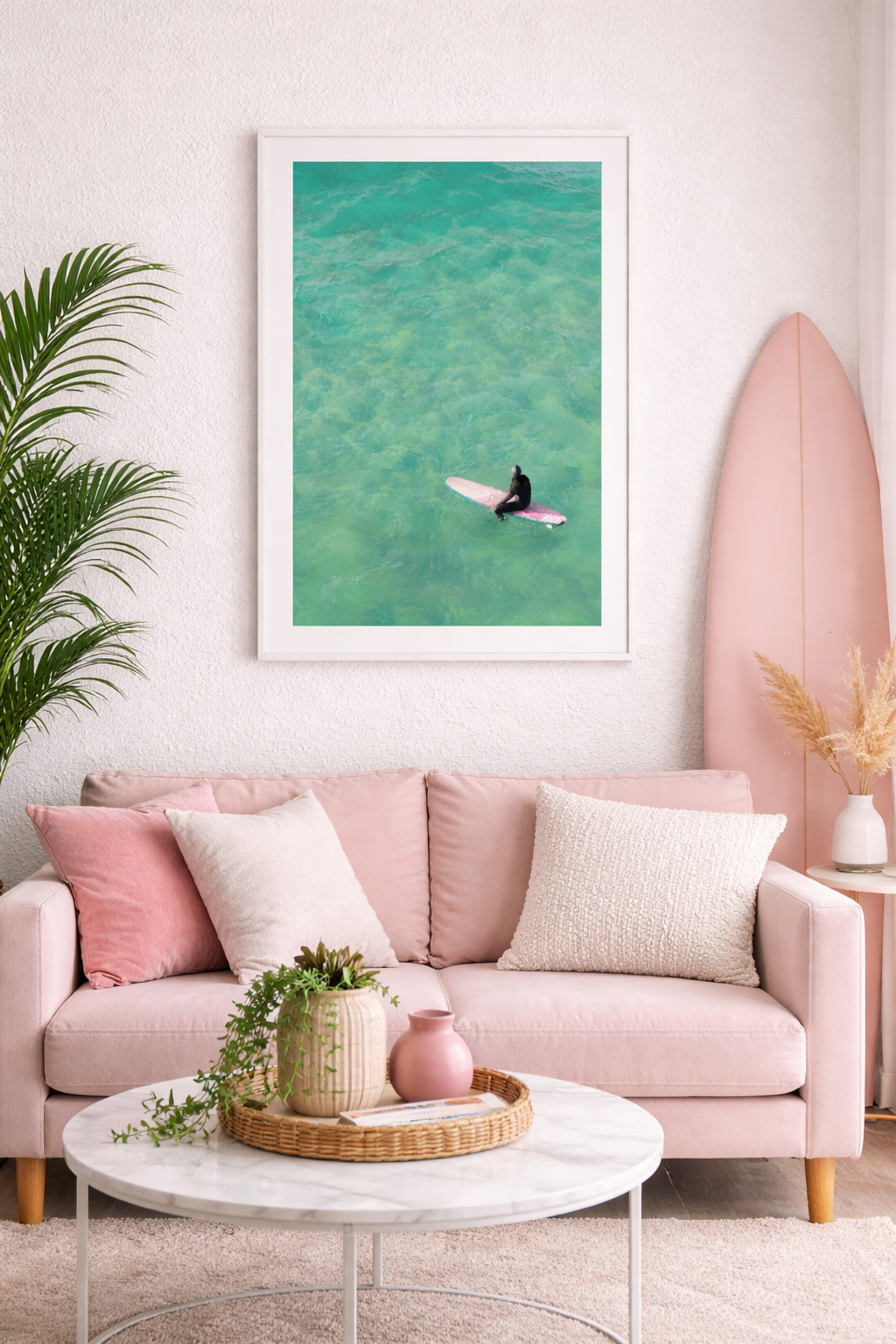 Living room with pink sofa, surfboard, and framed artwork of a Solo surfer girl on a pink surfboard in clear turquoise water