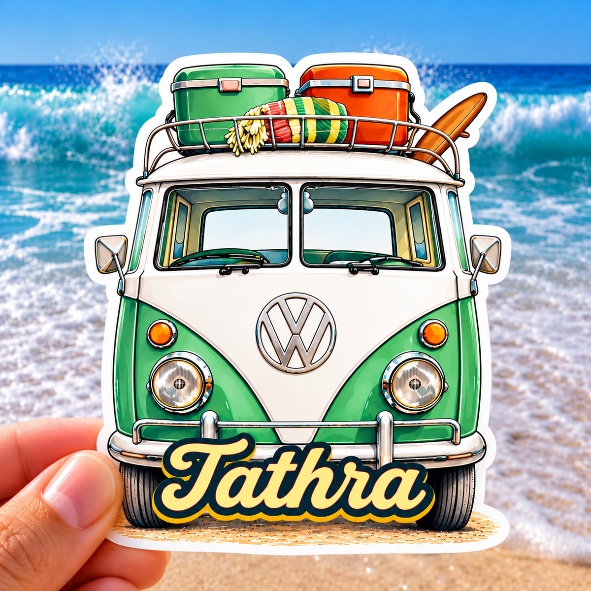 “Tathra retro Kombi van sticker with surfboard and colourful beach gear, photographed against a bright ocean and beach background.”