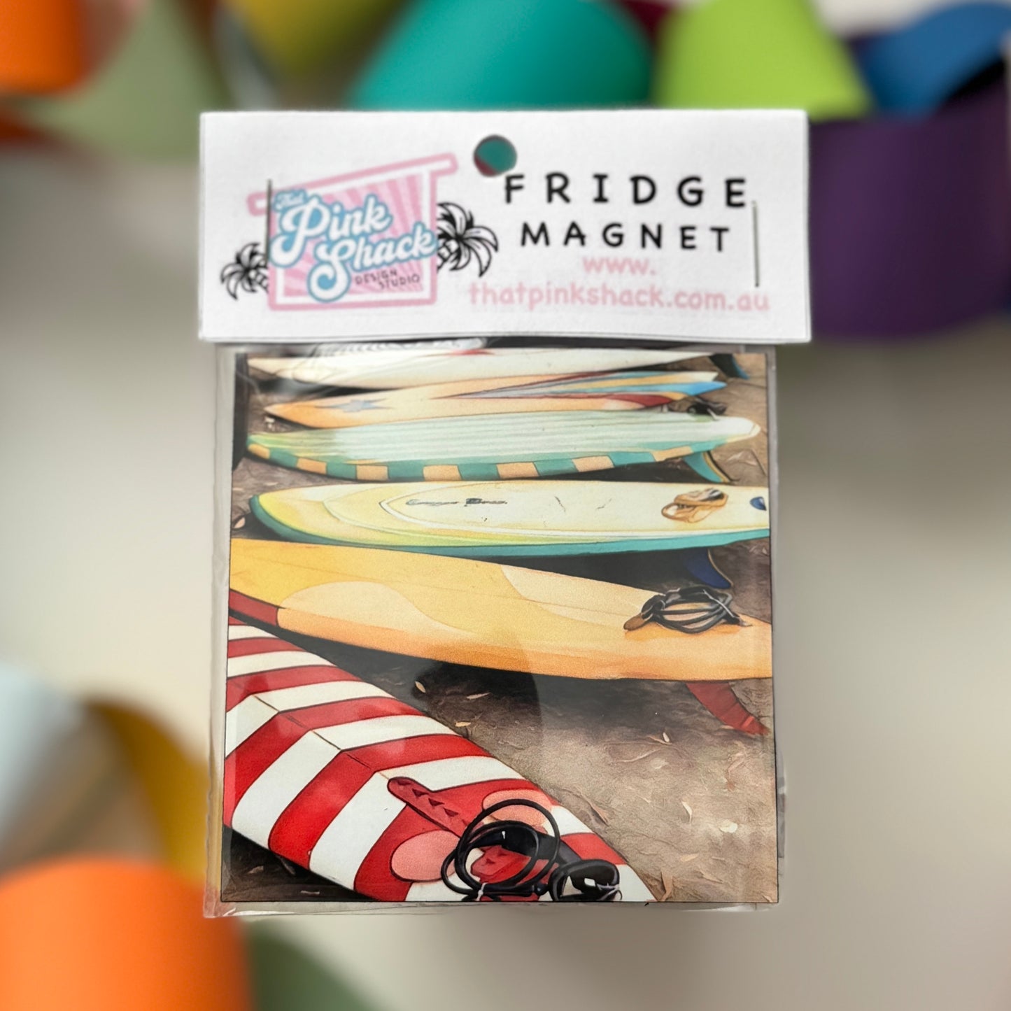 A fridge magnet with a collection of vintage surfboards in packaging